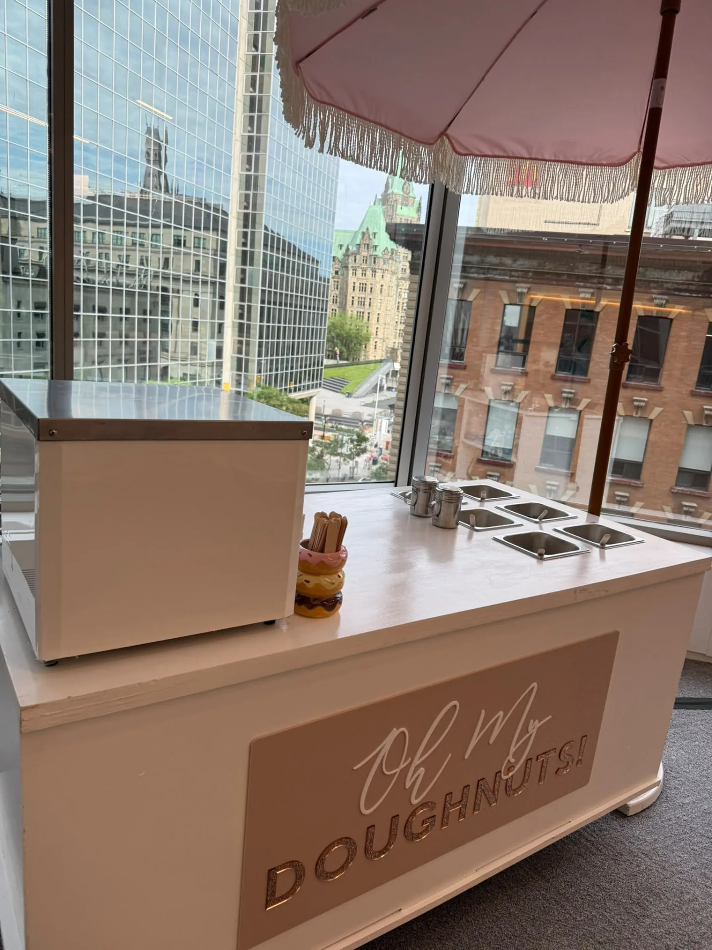 Branded Oh My Doughnuts corporate catering station beside office windows