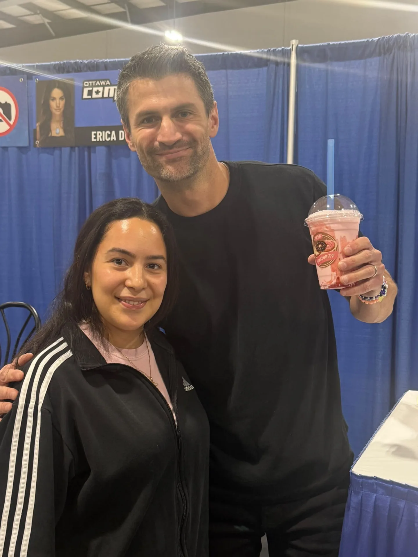 Comiccon guest holding a branded pink Oh My Doughnuts shake